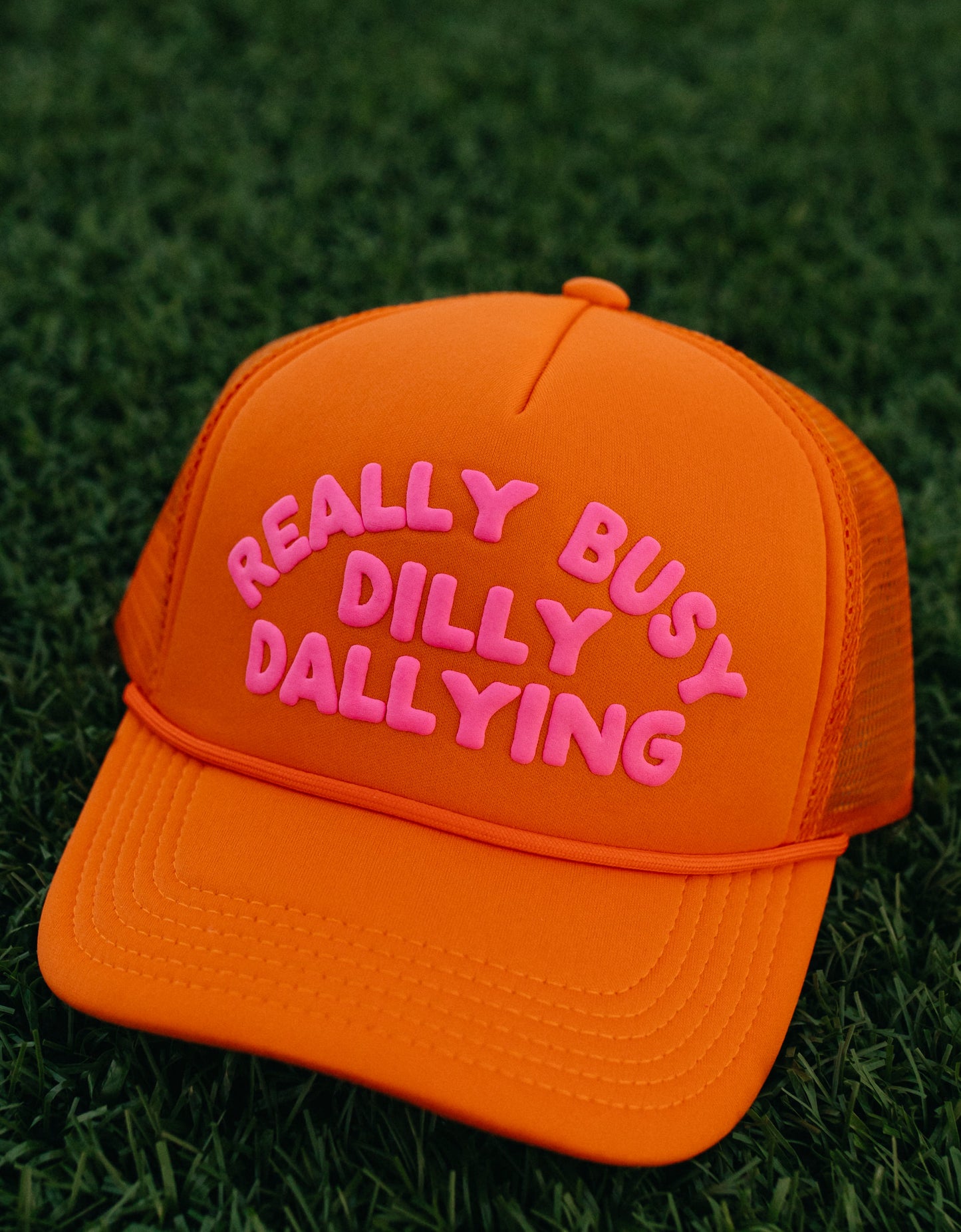 Really Busy Dilly Dallying Trucker Hat in Orange/Pink