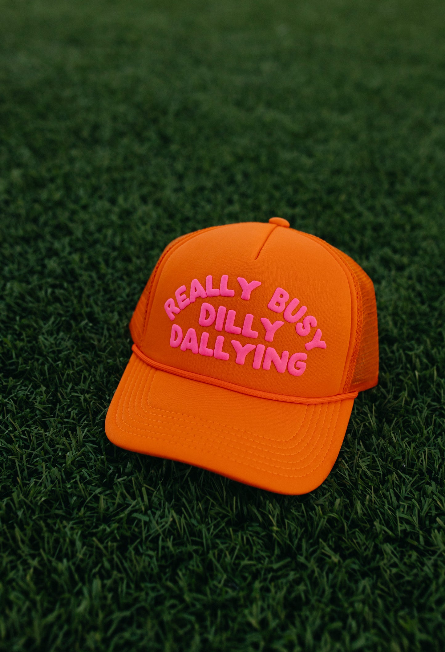 Really Busy Dilly Dallying Trucker Hat in Orange/Pink