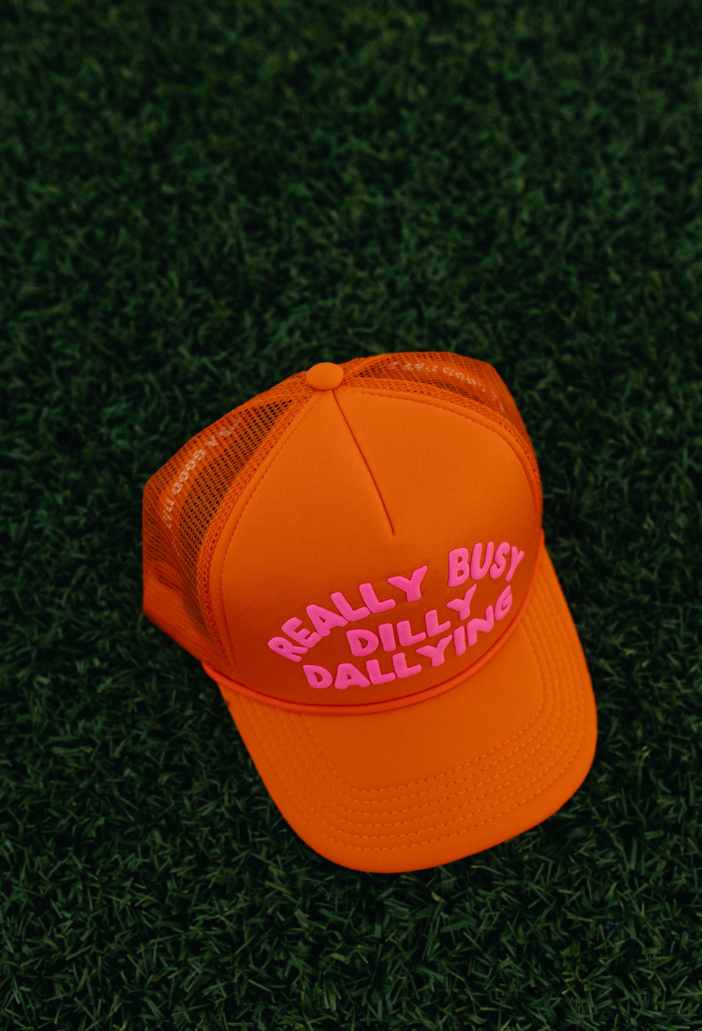 Really Busy Dilly Dallying Trucker Hat in Orange/Pink